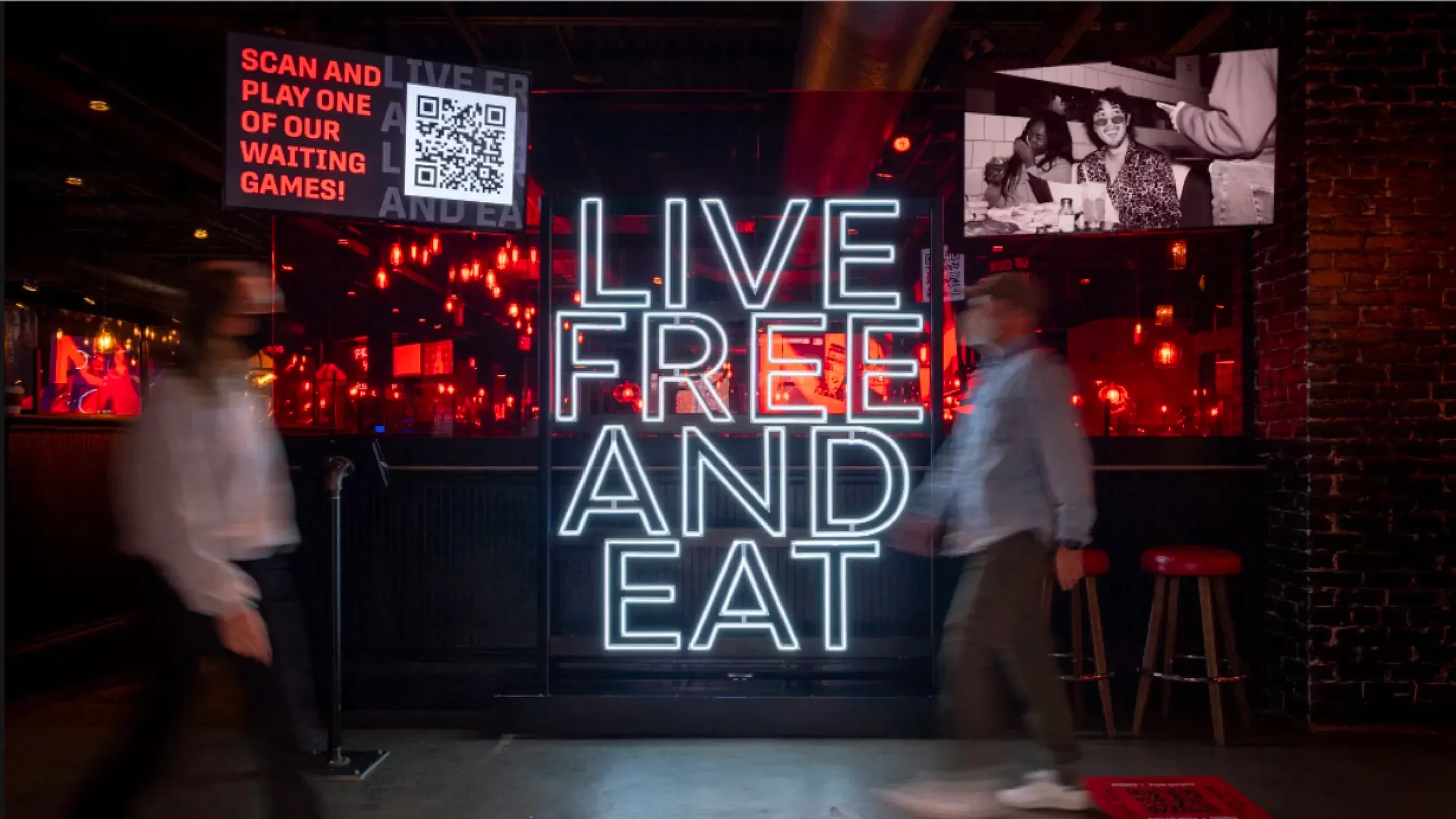 Jack Astor’s restaurant entrance featuring a bold neon "Live Free and Eat" tagline sign as part of the renegade brand refresh.